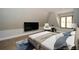 Bright bedroom with a large TV and a comfy white chair at 115 Russell Rd, Roswell, GA 30075