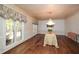 Formal dining room with chandelier, hardwood floors, and bright natural light from the large windows at 115 Russell Rd, Roswell, GA 30075