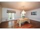 Bright dining room with hardwood floors, a chandelier, patterned wallpaper, and large bright windows at 115 Russell Rd, Roswell, GA 30075