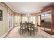 Elegant dining room boasting a beautiful chandelier, tiled floor and stainless steel fridge at 115 Russell Rd, Roswell, GA 30075