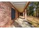 Brick covered porch extends along the back of the house with access to the back yard at 115 Russell Rd, Roswell, GA 30075