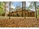 Brick house surrounded by a front yard with many colorful trees at 115 Russell Rd, Roswell, GA 30075