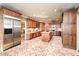 Wide angle of the kitchen showing custom wood cabinets, brick floors, stainless steel refrigerator, and center island at 115 Russell Rd, Roswell, GA 30075