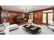 Elegant living room featuring a grand piano, wood paneled walls, and double doors to the exterior at 115 Russell Rd, Roswell, GA 30075