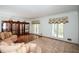 Inviting living room with hardwood floors, large windows, a display cabinet, and a comfortable sectional couch at 115 Russell Rd, Roswell, GA 30075
