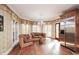 Sunlit living room with a sitting area, stainless steel refrigerator, and hardwood floors at 115 Russell Rd, Roswell, GA 30075