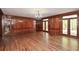 Spacious living room featuring hardwood floors, wood paneling, and a decorative chandelier at 115 Russell Rd, Roswell, GA 30075
