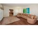Open living room with hardwood floors, a comfortable couch, and a view into an adjacent room at 115 Russell Rd, Roswell, GA 30075