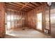 Spacious room with exposed wooden framing, window for natural light, and concrete flooring awaiting customization at 115 Russell Rd, Roswell, GA 30075