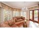 Sitting area with large windows, hardwood floors, and a stylish chandelier, providing ample natural light and charm at 115 Russell Rd, Roswell, GA 30075