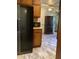 Traditional kitchen featuring wood cabinets, black fridge, and vinyl plank flooring at 35 Fairfield Dr, Ellenwood, GA 30294