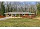 Brick ranch house with green shutters, covered porch, and landscaped lawn at 5310 Timbo Ln, Mableton, GA 30126