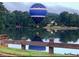 Hot air balloon over lake with houses and lush trees at 1805 Aurelia Dr, Cumming, GA 30041