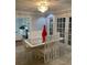 Formal dining room with a glass-top table, white chairs, and a modern chandelier at 1417 Doe Valley Dr, Lithonia, GA 30058