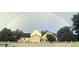 House exterior featuring a two-story home with a large yard and a rainbow in the background at 1417 Doe Valley Dr, Lithonia, GA 30058