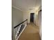 Upper hallway with carpeted floor and black railing at 1417 Doe Valley Dr, Lithonia, GA 30058