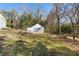 White detached garage with double doors, nestled in a wooded backyard at 3133 Callie Still Rd, Lawrenceville, GA 30045