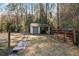 Small storage shed and red metal gate in wooded area at 3133 Callie Still Rd, Lawrenceville, GA 30045