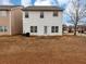 A two-story home features a backyard with grass, complemented by a white exterior and window accents at 141 Whimsical Ct, Locust Grove, GA 30248