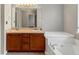 Bathroom featuring double sinks, a large mirror, and a soaking tub at 141 Whimsical Ct, Locust Grove, GA 30248