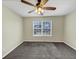 Neutral-toned bedroom with a ceiling fan and a window letting in natural light at 141 Whimsical Ct, Locust Grove, GA 30248