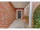 Inviting front entrance with a brick wall, covered porch, and a dark wooden door at 141 Whimsical Ct, Locust Grove, GA 30248