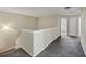Carpeted upstairs hallway featuring white trim and neutral walls, filled with natural light at 141 Whimsical Ct, Locust Grove, GA 30248