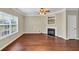 Cozy living room with a fireplace, hardwood floors, and a large window at 141 Whimsical Ct, Locust Grove, GA 30248