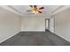 Main bedroom featuring plush carpet, neutral walls, tray ceiling, and a ceiling fan at 141 Whimsical Ct, Locust Grove, GA 30248