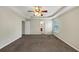 Main bedroom featuring plush carpet, neutral walls, tray ceiling, and a ceiling fan at 141 Whimsical Ct, Locust Grove, GA 30248