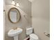 Stylish powder room featuring a pedestal sink, a round gold mirror and modern gold fixtures at 141 Whimsical Ct, Locust Grove, GA 30248