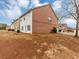 The side exterior of a brick two-story house shows the yard and driveway and neighboring house at 141 Whimsical Ct, Locust Grove, GA 30248