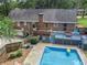 Backyard view with large pool, patio, deck, brick exterior, and a fenced yard offering privacy at 5513 N Peachtree Rd, Dunwoody, GA 30338
