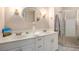 Bathroom with double vanity, shower, and white cabinets at 5513 N Peachtree Rd, Dunwoody, GA 30338