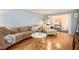 Living area featuring hardwood floors, sectional sofa, and large windows at 5513 N Peachtree Rd, Dunwoody, GA 30338