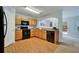 Modern kitchen with wood cabinets, black appliances, and wood-look floors at 4676 Ravenwood Loop, Union City, GA 30291