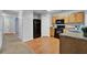 Kitchen with wood cabinets, black appliances, and a view of the hallway at 4676 Ravenwood Loop, Union City, GA 30291