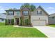 Two-story house with brick and siding, landscaped lawn, and driveway at 6235 Stillwood Ln, Cumming, GA 30041