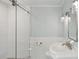 Modern bathroom with a pedestal sink, glass shower, and white tile at 566 Church Ne St, Marietta, GA 30060