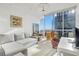 Cozy living room with floor-to-ceiling windows showcasing city views, complete with sofa and workspace at 3325 Piedmont Ne Rd # 2702, Atlanta, GA 30305