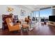 Cozy living room showcasing hardwood floors, comfortable seating, piano and expansive windows with city views at 3325 Piedmont Ne Rd # 2702, Atlanta, GA 30305
