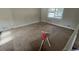 Empty living room with brown carpet and large window at 1272 Marlwood Ct, Stone Mountain, GA 30083