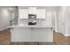 Spacious kitchen island with granite countertops and seating overlooks the dining area and staircase at 4150 Cavalier Way, Duluth, GA 30097