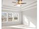 A main bedroom featuring a tray ceiling and large windows at 4150 Cavalier Way, Duluth, GA 30097