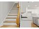 Stairway with wood handrail, adjacent to a modern kitchen with stainless steel appliances at 4150 Cavalier Way, Duluth, GA 30097