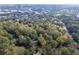 An aerial view of a home nestled among trees, showcasing the surrounding neighborhood and city skyline at 1141 Goodwin Ne Pl, Brookhaven, GA 30319