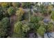 An overhead shot reveals the home, surrounded by mature trees near a paved road at 1141 Goodwin Ne Pl, Brookhaven, GA 30319