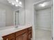 Bathroom featuring a single sink vanity, a large mirror, and walk-in closet with ample shelving at 1965 Nocturne Dr # 1209, Alpharetta, GA 30009