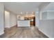 Open-concept living room with wood flooring adjacent to kitchen and light gray walls at 1965 Nocturne Dr # 1209, Alpharetta, GA 30009