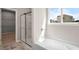 Bright bathroom with tub, glass shower door, and walk-in closet at 106 Cherry Glen Way, Euharlee, GA 30145